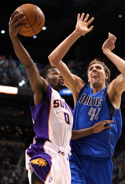 PHOENIX, AZ - MARCH 27:  Aaron Brooks #0 of the Phoenix Suns lays up a shot past Dirk Nowitzki #41 of the Dallas Mavericks during the NBA game at US Airways Center on March 27, 2011 in Phoenix, Arizona. The Mavericks defeated the Suns 91-83. NOTE TO USER: