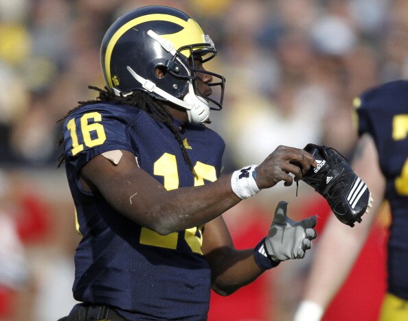 ANN ARBOR, MI - NOVEMBER 20:  Denard Robinson #16 of the Michigan Wolverines puts his shoe back on while playing the Wisconsin Badgers tackles at Michigan Stadium on November 20, 2010 in Ann Arbor, Michigan. Wisconsin won the game 48-38.  (Photo by Gregor