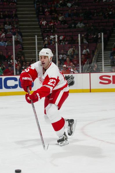 EAST RUTHERFORD, NJ - DECEMBER 16:  Mathieu Schneider #23 of the Detroit Red Wings moves the puck against the New Jersey Devils on December 16, 2006 at Continental Airlines Arena in East Rutherford, New Jersey. The Red Wings won 2-1. (Photo by Bruce Benne
