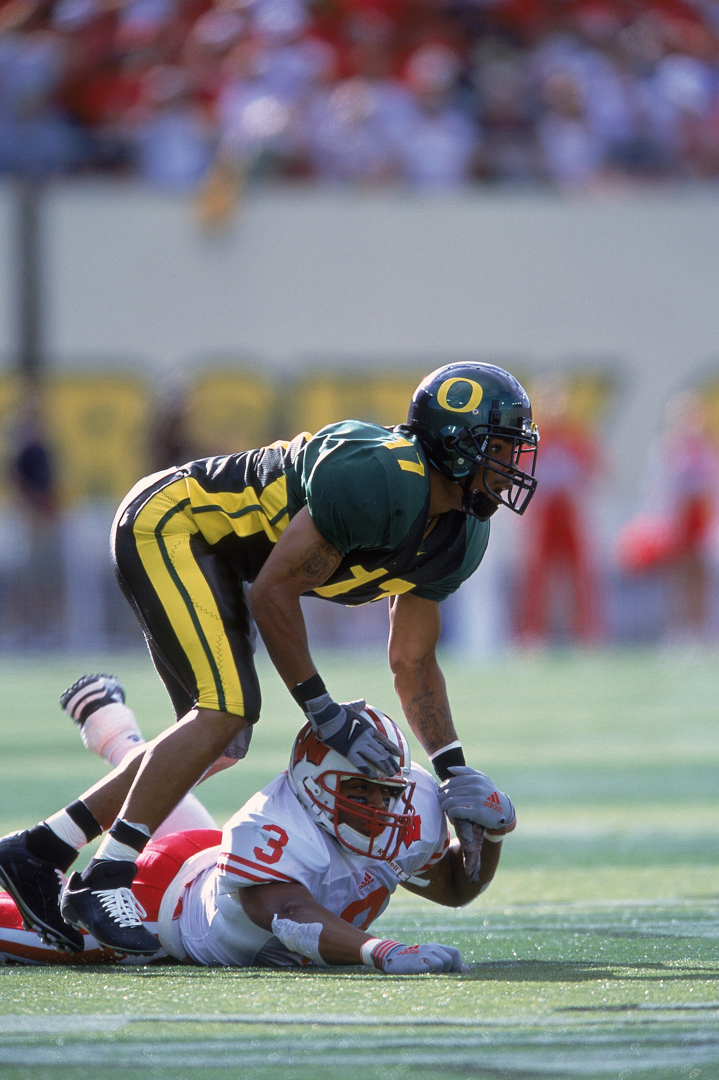 1 Sep 2001:  Rashad Bauman #17 of the Oregon Ducks holding down Lee Evans #3 during the game against the Wisconsin Badgers at Autzen Stadium in Eugene, Oregon. The Ducks defeated the Badgers 31-28.Mandatory Credit: Otto Greule  /Allsport