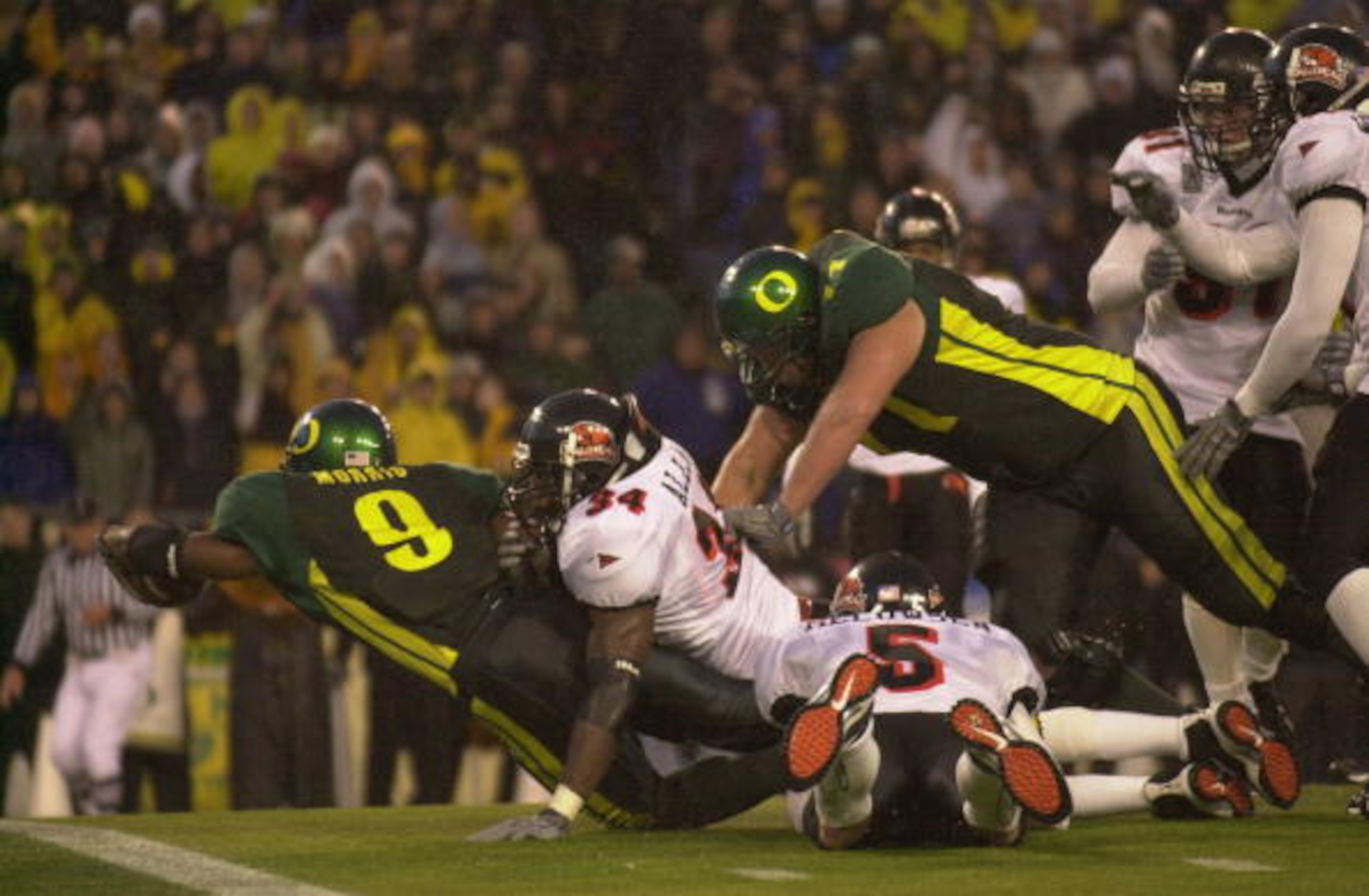 EUGENE, OR - DECEMBER 1:  Tailback Maurice Morris #9 of Oregon Ducks dives for the goalline against linebacker James Allen #34 of the Oregon State Beavers at Autzen Stadium in Eugene Oregon on December 1, 2001.  Oregon defeated Oregon State 17-14.  (Photo