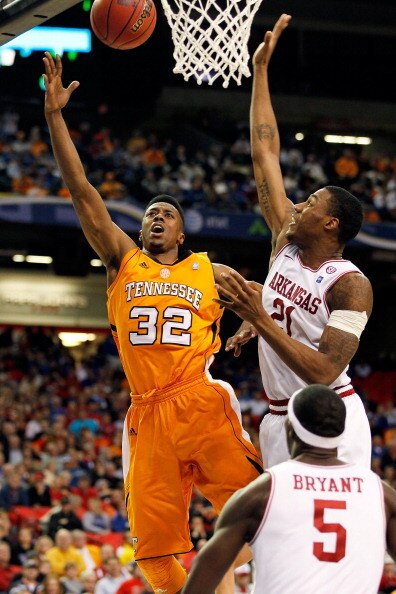 ATLANTA, GA - MARCH 10:  Scotty Hopson #32 of the Tennessee Volunteers shoots over Delvon Johnson #21 and Glenn Bryant #5 of the Arkansas Razorbacks during the first round of the SEC Men's Basketball Tournament at the Georgia Dome on March 10, 2011 in Atl