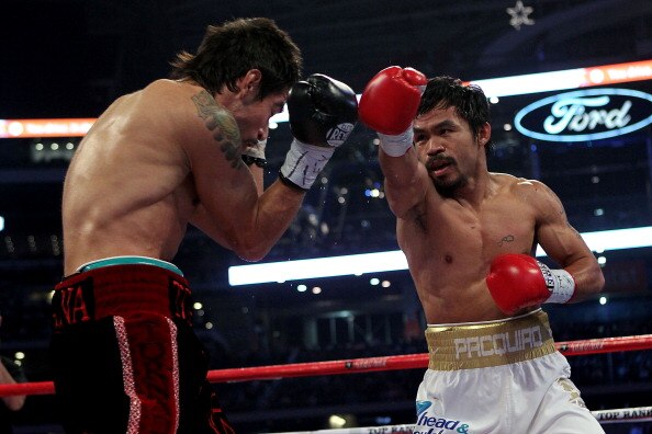 ARLINGTON, TX - NOVEMBER 13:  Manny Pacquiao (white trunks) of the Philippines throws a punch against Antonio Margarito (black trunks) of Mexico during their WBC World Super Welterweight Title bout at Cowboys Stadium on November 13, 2010 in Arlington, Tex