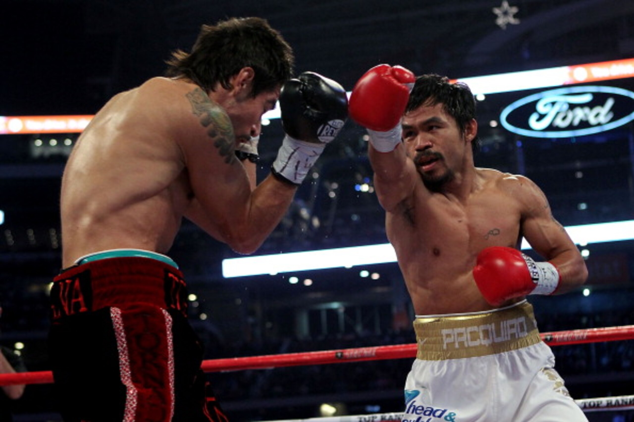 ARLINGTON, TX - NOVEMBER 13:  Manny Pacquiao (white trunks) of the Philippines throws a punch against Antonio Margarito (black trunks) of Mexico during their WBC World Super Welterweight Title bout at Cowboys Stadium on November 13, 2010 in Arlington, Tex