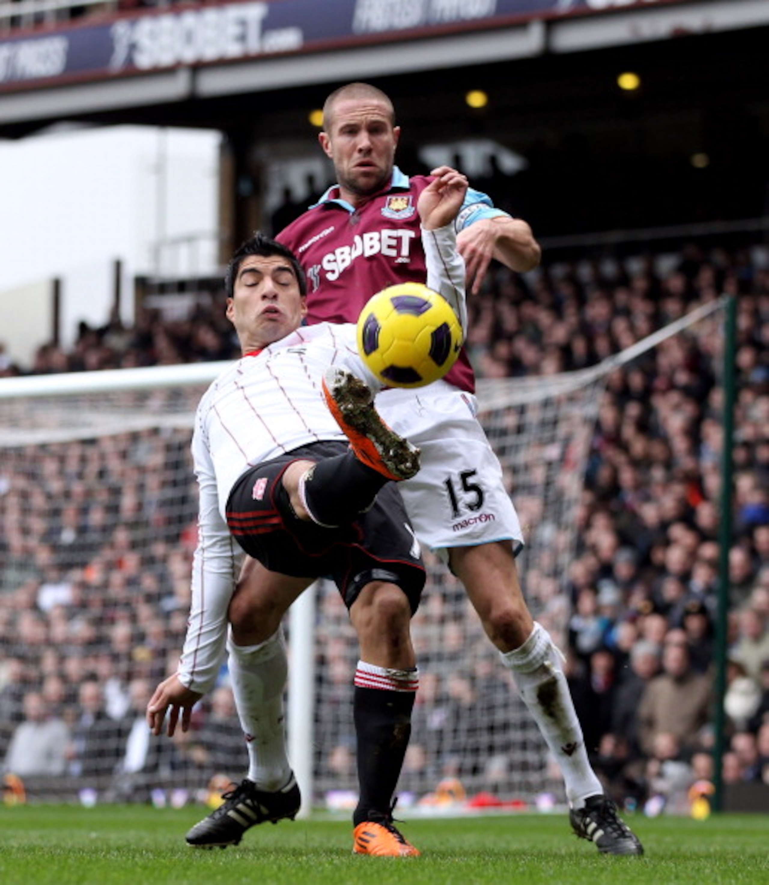 LONDON, ENGLAND - FEBRUARY 27:  Luis Suarez of Liverpool (front) tangles with Matthew Upson of West Ham during the Barclays Premier League match between West Ham United and Liverpool at the Boleyn Ground on February 27, 2011 in London, England.  (Photo by
