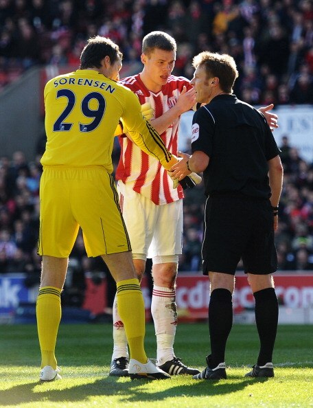 STOKE ON TRENT, ENGLAND - MARCH 13:  Referee Mike Jones is confronted by Ryan Shawcross of Stoke City and goalkeeper Thomas Sorensen of Stoke City after allowing the opening West Ham United goal during the FA Cup sponsored by E.ON 6th Round match between