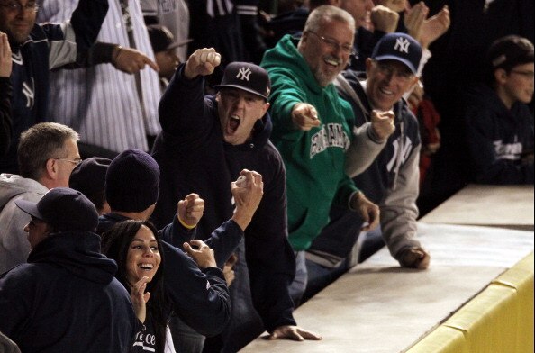 NEW YORK - OCTOBER 19:  Fans react after catching a home run ball hit by Robinson Cano #24 of the New York Yankees in the bottom of the second inning of Game Four of the ALCS during the 2010 MLB Playoffs at Yankee Stadium on October 19, 2010 in the Bronx