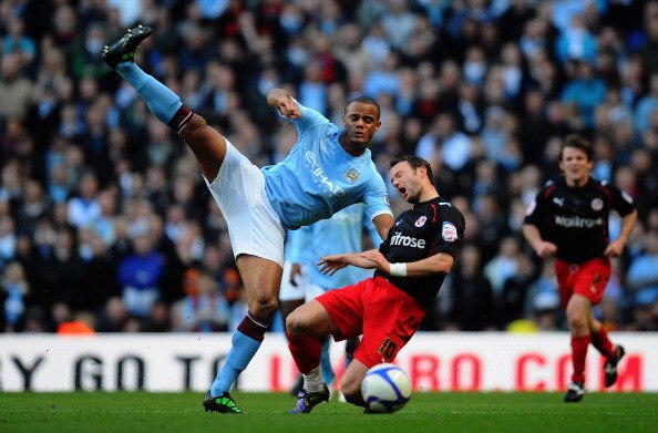 MANCHESTER, ENGLAND - MARCH 13:  Vincent Kompany of Manchester City tackles Noel Hunt of Reading during the FA Cup sponsored by E.On Sixth Round match between Manchester City and Reading at the City of Manchester Stadium on March 13, 2011 in Manchester, E