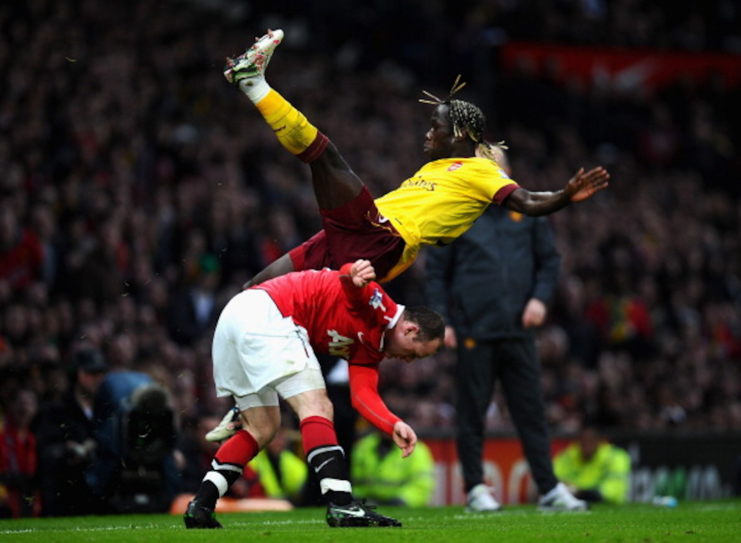 MANCHESTER, ENGLAND - MARCH 12:  Bacary Sagna of Arsenal falls over Wayne Rooney of Manchester United during the FA Cup sponsored by E.On Sixth Round match between Manchester United and Arsenal at Old Trafford on March 12, 2011 in Manchester, England.  (P