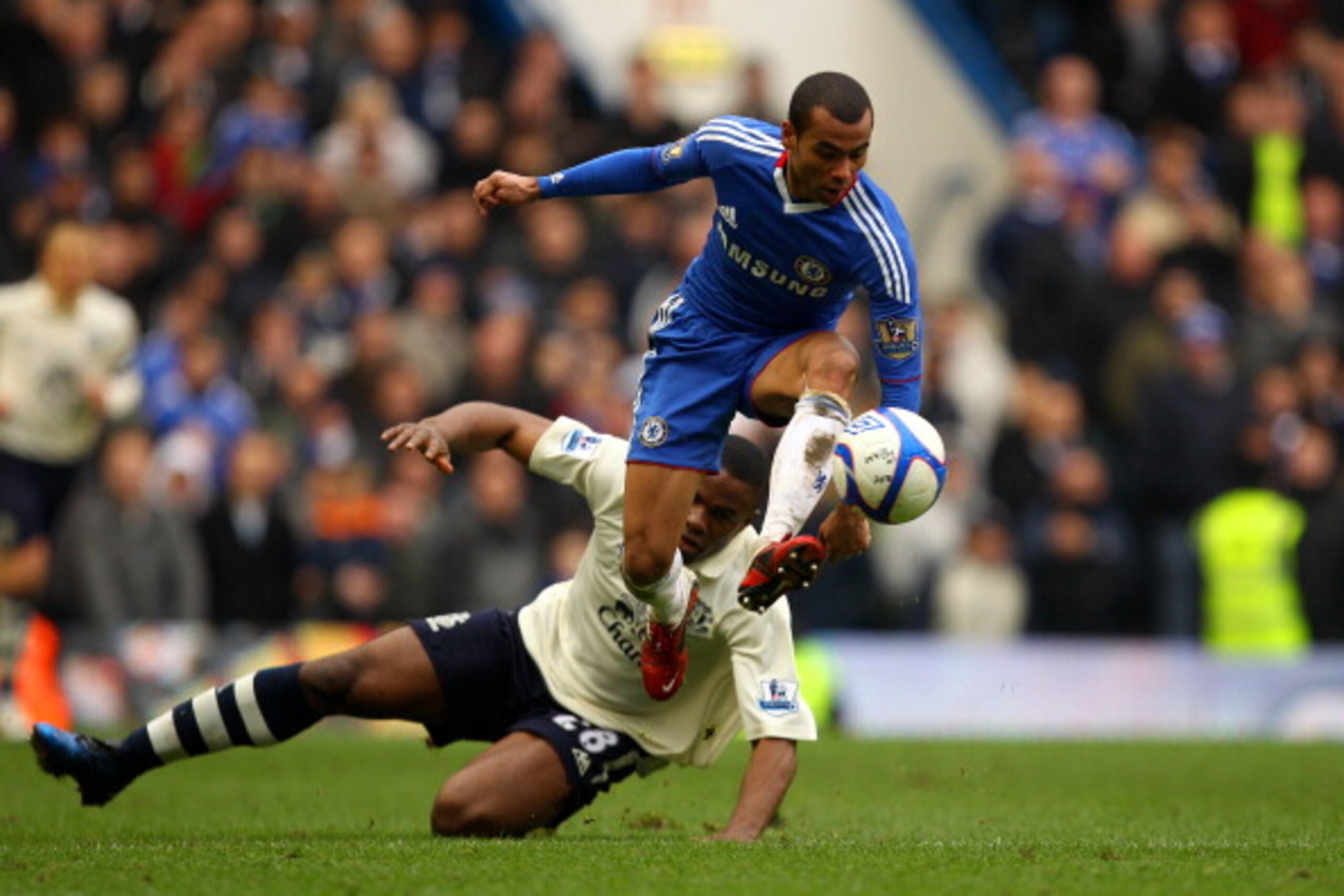 LONDON, ENGLAND - FEBRUARY 19:  Ashley Cole of Chelsea controls the ball as Victor Anichebe of Everton looks on during the FA Cup sponsored by E.ON 4th round replay match between Chelsea and Everton at Stamford Bridge on February 19, 2011 in London, Engla