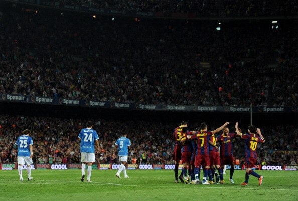 BARCELONA, SPAIN - APRIL 09:  Lionel Messi (R) of Barcelona runs to join his teammates celebrating Thiago Alcantara his goal as Almeria players trudge back to the halfway line during the la Liga match between FC Barcelona and UD Almeria at the Camp Nou st