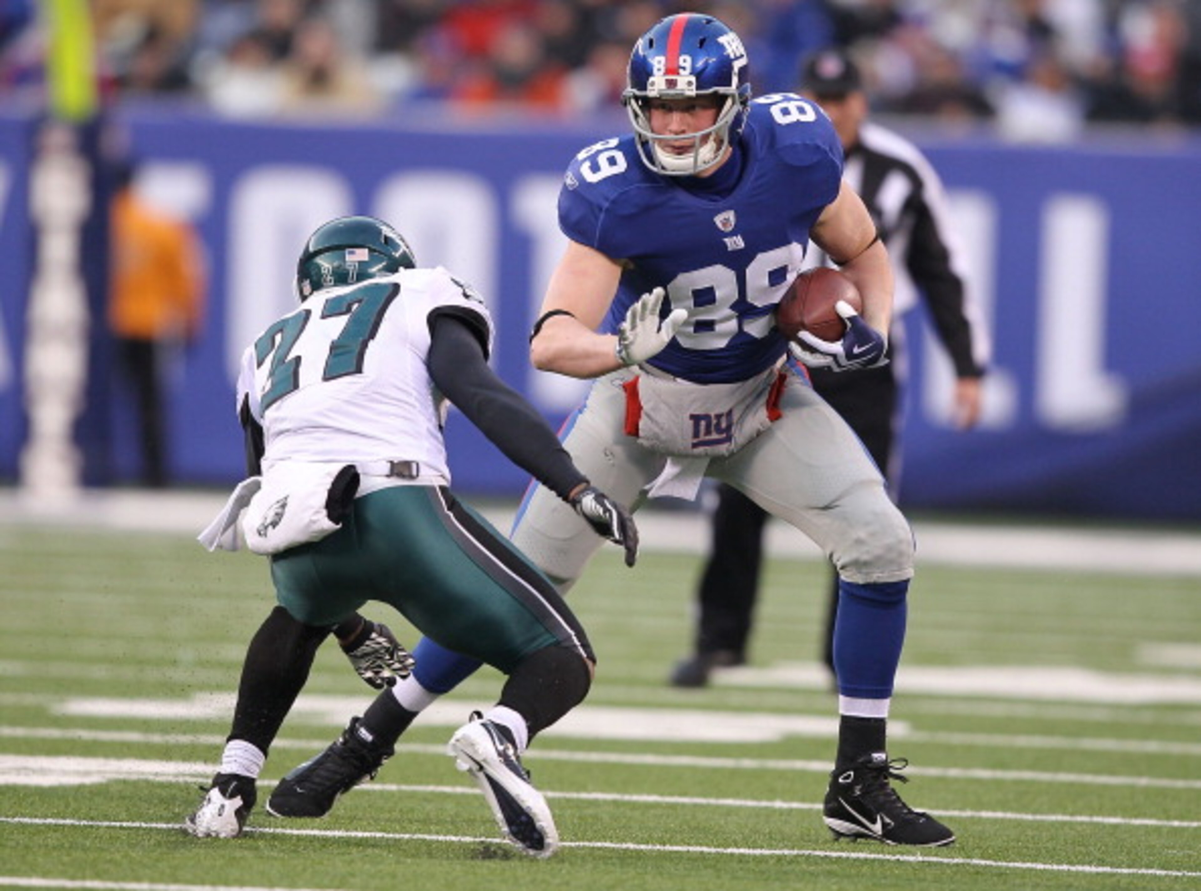 EAST RUTHERFORD, NJ - DECEMBER 19:  Kevin Boss #89 of the New York Giants eludes the tackle of Quintin Mikell #27 of the Philadelphia Eagles during their game on December 19, 2010 at The New Meadowlands Stadium in East Rutherford, New Jersey.  (Photo by A