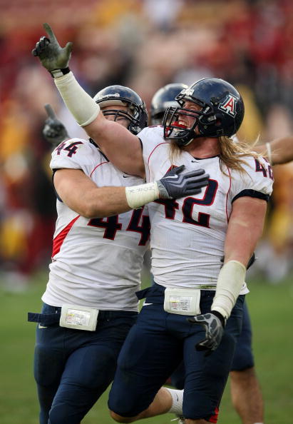 LOS ANGELES, CA - DECEMBER 05:  Defensive ends Brooks Reed #42 and Ricky Elmore #44 of the Arizona Wildcats celebrate after stopping the USC Trojans on the final play on December 5, 2009 at the Los Angeles Coliseum in Los Angeles, California. Arizona won 