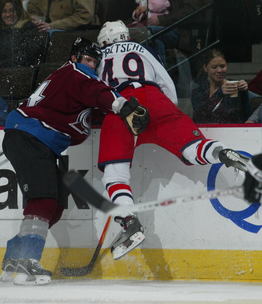 DENVER - DECEMBER 5: John-Michael Liles #4 of the Colorado Avalanche gets hit by Dan Fritsche #49 of the Columbus Blue Jackets on December 5, 2006 at the Pepsi Center in Denver, Colorado. The Blue Jackets shut out the Avalanche 3-0.  (Photo by Bruce Benne