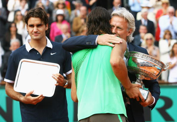 PARIS - JUNE 08:  Rafael Nadal of Spain receives the trophy from Bjorn Borg, as runner up Roger Federer (L) of Switzerland looks on after the Men's Singles Final match on day fifteen of the French Open at Roland Garros on June 8, 2008 in Paris, France.  (