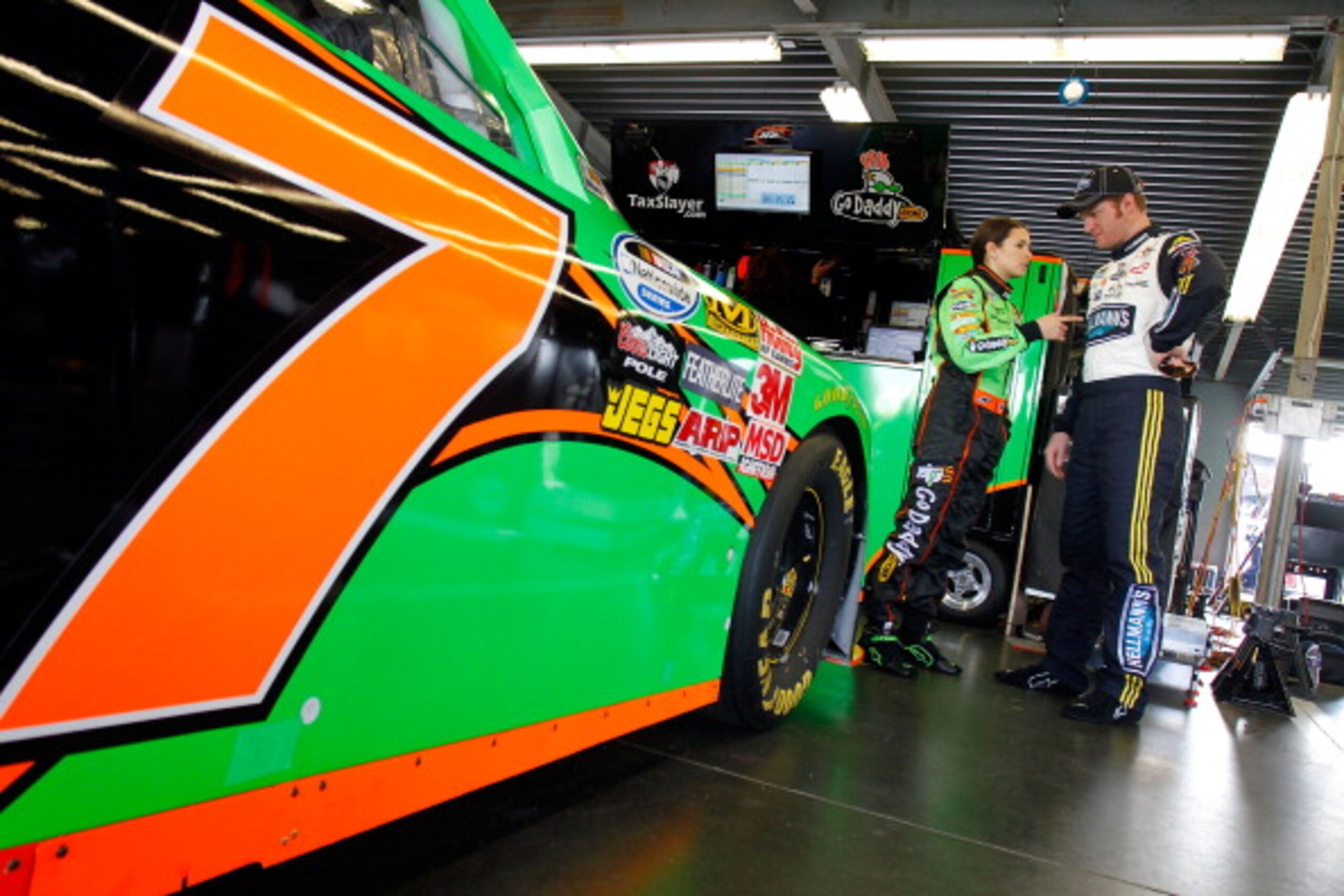 DAYTONA BEACH, FL - FEBRUARY 17:  Danica Patrick (L), driver of the #7 GoDaddy.com Chevrolet, talks with Dale Earnhardt Jr. (R), driver of the #5 Hellmann's Chevrolet, in the garage during practice for the NASCAR Nationwide Series DRIVE4COPD 300 at Dayton