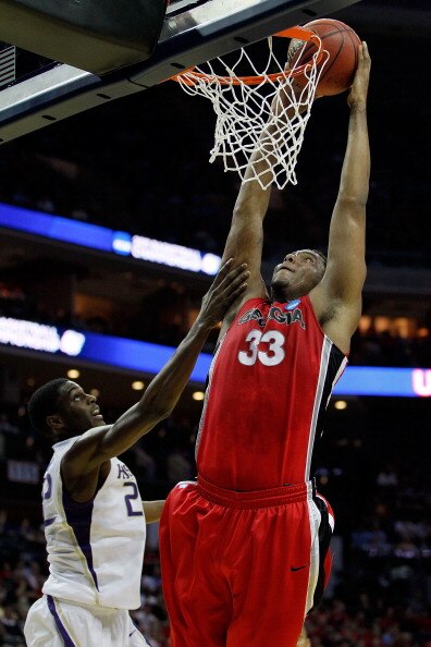 CHARLOTTE, NC - MARCH 18:  Trey Thompkins #33 of the Georgia Bulldogs goes up for a dunk over Justin Holiday #22 of the Washington Huskies in the first half during the second round of the 2011 NCAA men's basketball tournament at Time Warner Cable Arena on