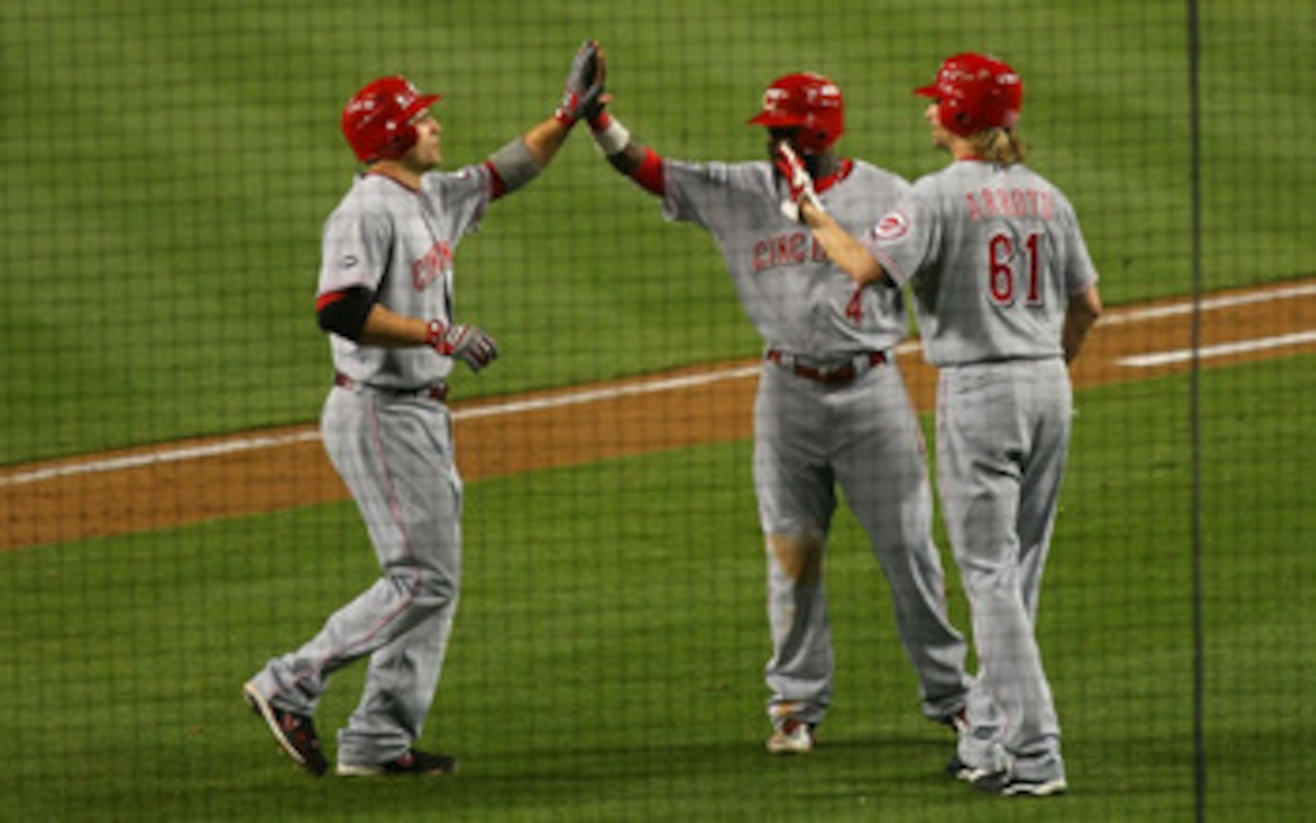 LOS ANGELES, CA - JUNE 13:  Joe Votto #19 of the Cincinnati Reds high fives with teammates Brandon Phillips #4 and Brandon Arroyo #61 after hitting a three-run home run in the seventh inning against the Los Angeles Dodgers during the MLB game at Dodger St