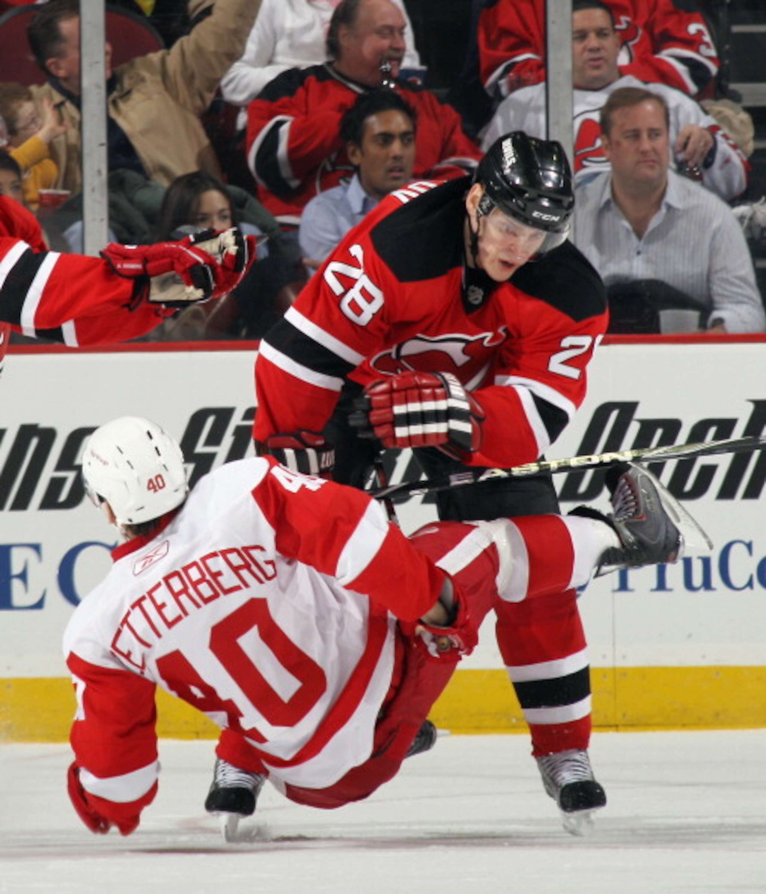 NEWARK, NJ - DECEMBER 11: Henrik Zetterberg #40 of the Detroit Red Wings is hit by Anton Volchenkov #28 of the New Jersey Devils at the Prudential Center on December 11, 2010 in Newark, New Jersey.  (Photo by Bruce Bennett/Getty Images)