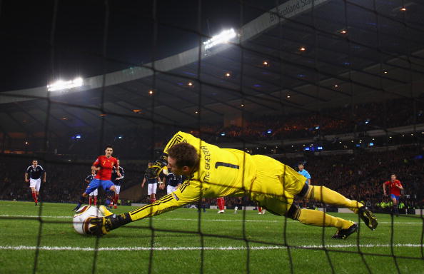 GLASGOW, SCOTLAND - OCTOBER 12:  David Villa of Spain beats Allan McGregor of Scotland from the penalty spot for the opening goal during the UEFA EURO 2012 Group I Qualifier match between Scotland and Spain at Hampden Park on October 12, 2010 in Glasgow,