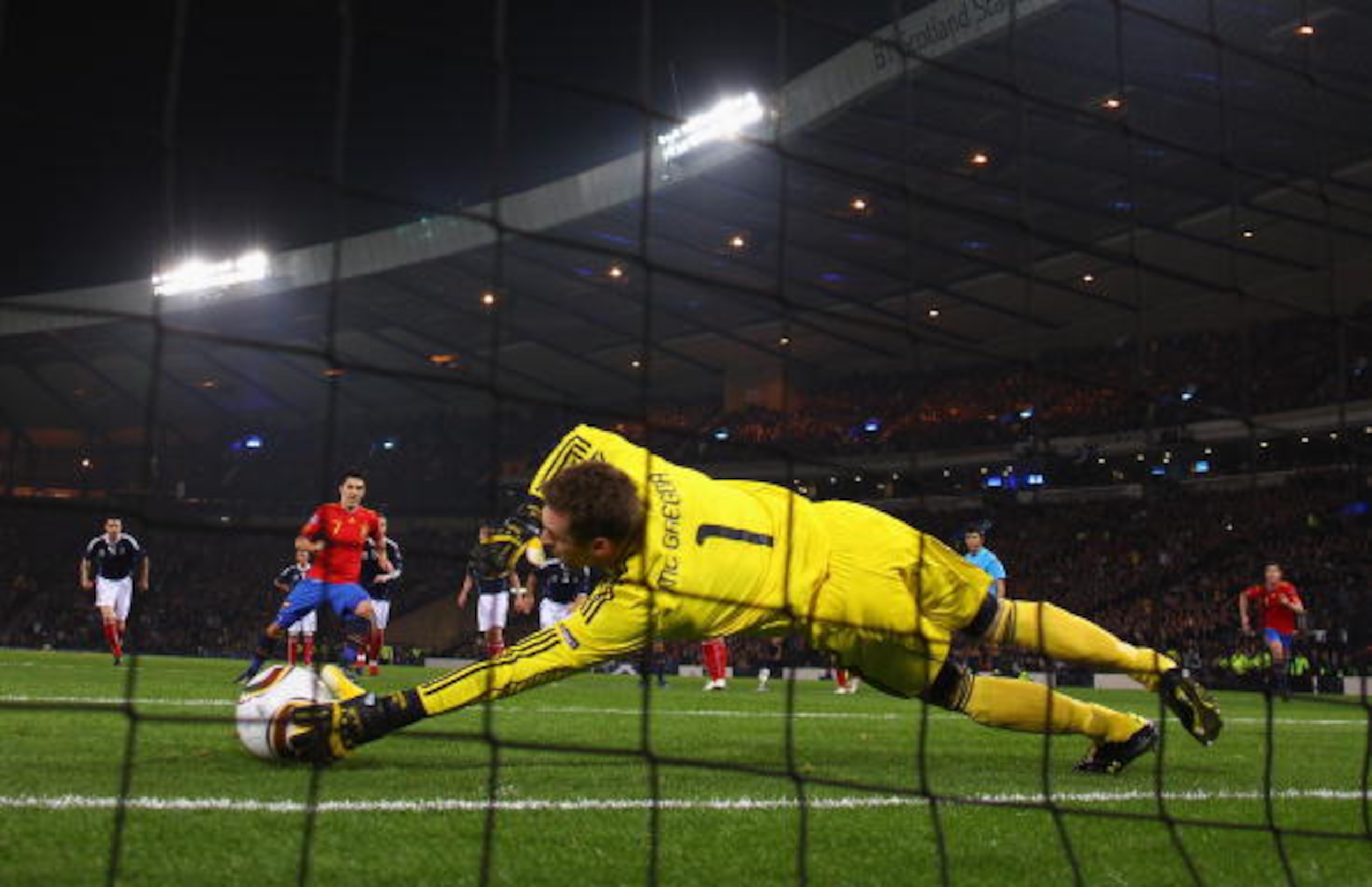 GLASGOW, SCOTLAND - OCTOBER 12: David Villa of Spain beats Allan McGregor of Scotland from the penalty spot for the opening goal during the UEFA EURO 2012 Group I Qualifier match between Scotland and Spain at Hampden Park on October 12, 2010 in Glasgow, GLASGOW, SCOTLAND - OCTOBER 12: David Villa of Spain beats Allan McGregor of Scotland from the penalty spot for the opening goal during the UEFA EURO 2012 Group I Qualifier match between Scotland and Spain at Hampden Park on October 12, 2010 in Glasgow,