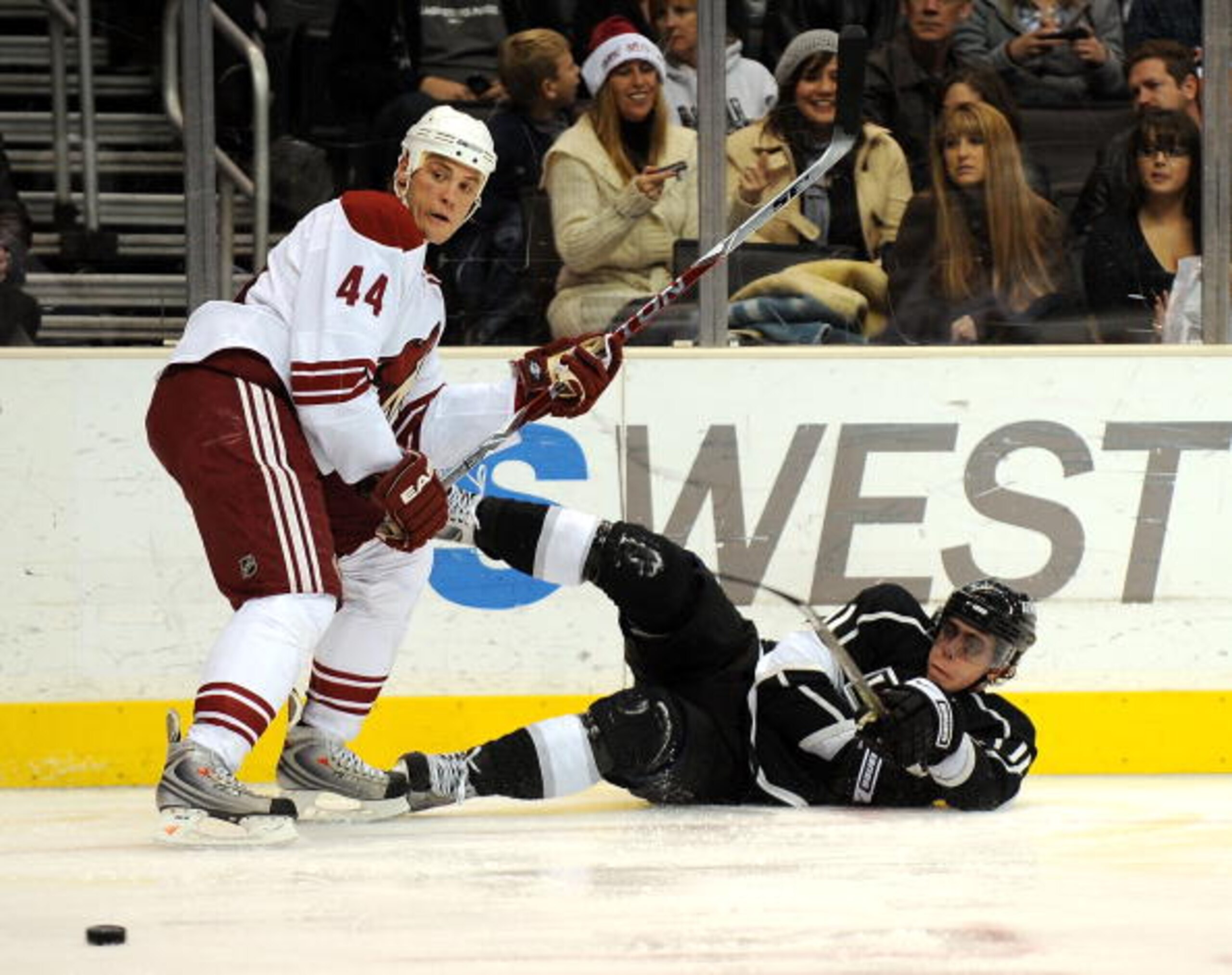 LOS ANGELES, CA - DECEMBER 26:  Anze Kopitarl #11 of the Los Angeles Kings shoots the puck as he falls to the ice in front of Kurt Sauer #44 of the Phoenix Coyotes during the second period at the Staples Center on December 26, 2008 in Los Angeles, Califor