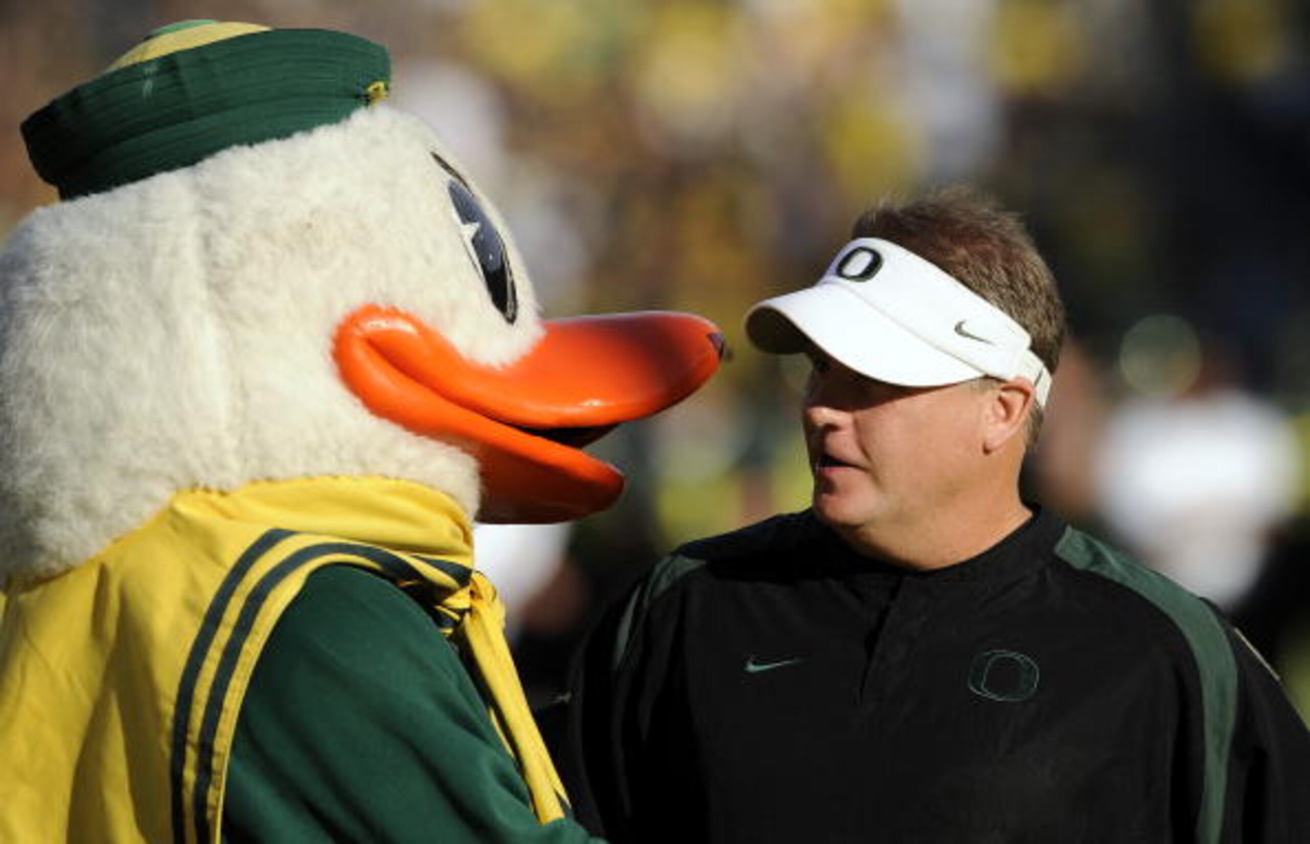 EUGENE, OR - OCTOBER 2: Head coach Chip Kelly of the Oregon Ducks is greeted by 'Puddles', the mascot of the Oregon Ducks, before the game against the Stanford Cardinal at Autzen Stadium on October 2, 2010 in Eugene, Oregon. Oregon won the game 52-31. (Ph
