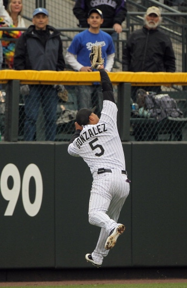 DENVER, CO - APRIL 06:  Leftfielder Carlos Gonzalez #5 of the Colorado Rockies leaps as he nears the wall to catch a fly ball by Rafael Furcal #15 of the Los Angeles Dodgers for the first out of the ninth inning at Coors Field on April 6, 2011 in Denver,