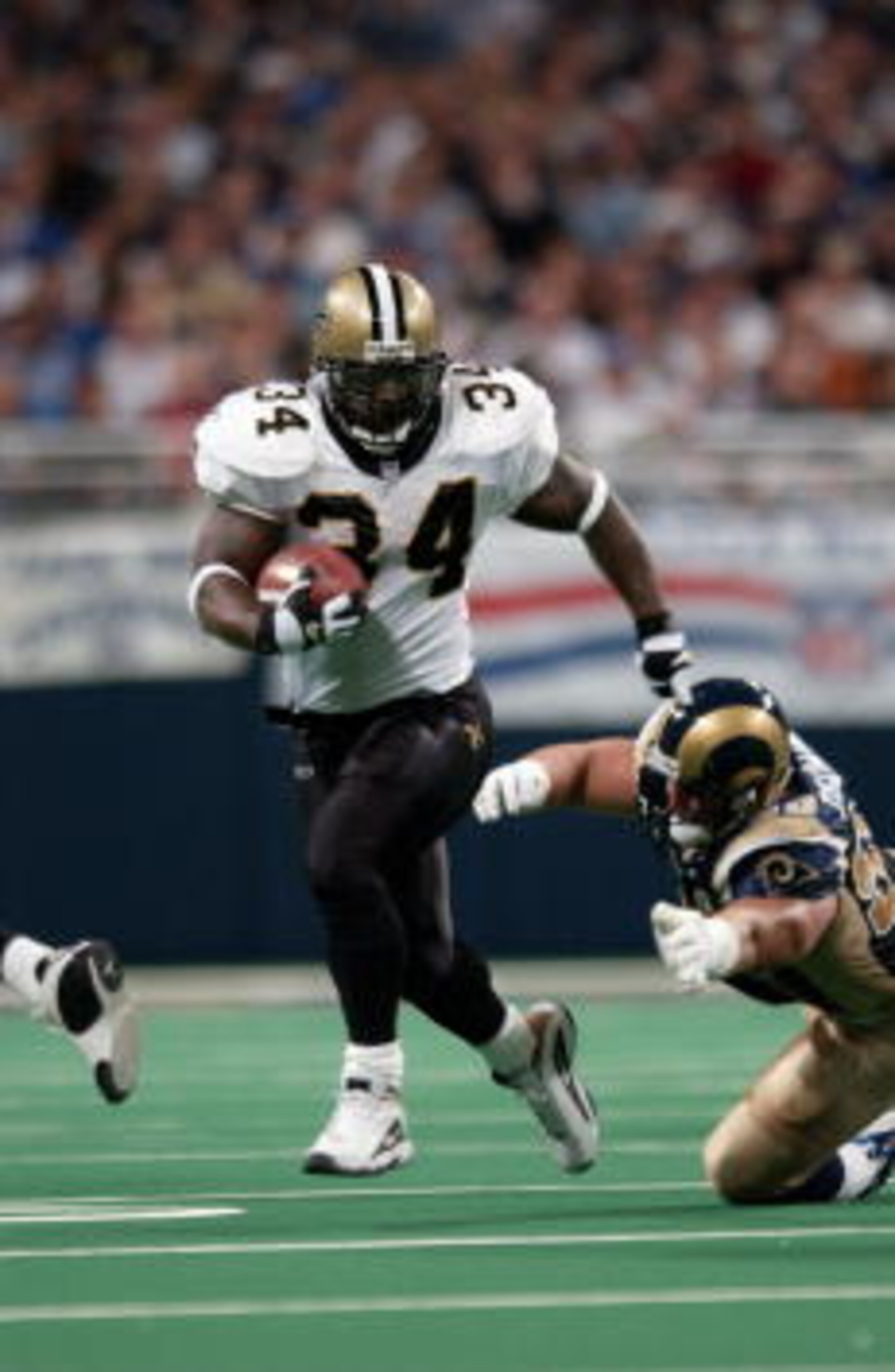 28 Oct 2001 : Ricky Williams #34 of the New Orleans Saints outruns a tackle by the St.Louis Rams during the game at the Dome at the America's Center in St.Louis, Missouri.  The Saints beat the Rams 34-31. DIGITAL IMAGE. Mandatory Credit: Elsa/Allsport