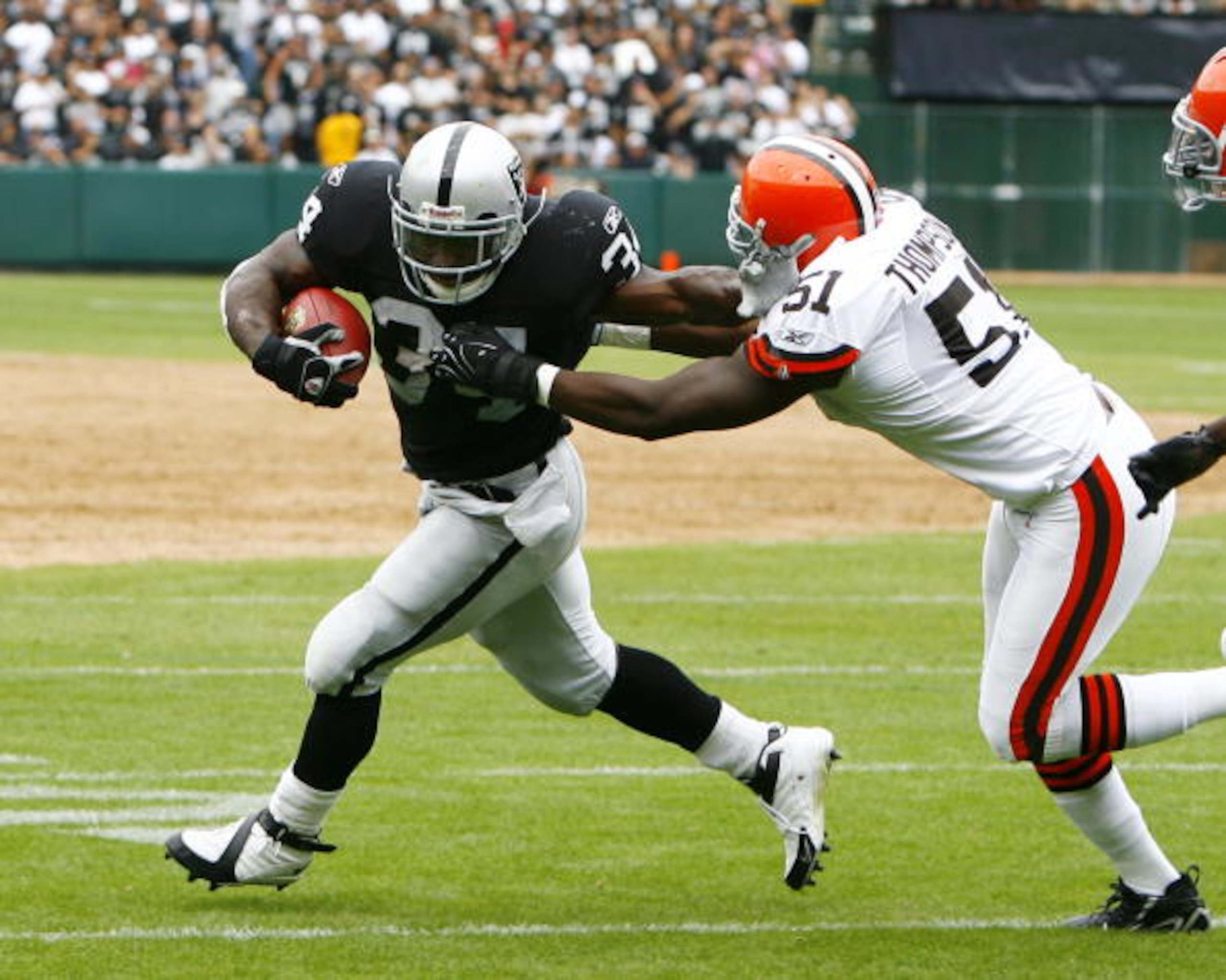 OAKLAND, CA - SEPTEMBER 23:  Running back LaMont Jordan #34 of the Oakland Raiders  tries to elude linebacker Chaun Thompson #51 of the Cleveland Browns during a 26-24 win at McAfee Coliseum on September 23, 2007 in Oakland, California.  (Photo by Kevin T