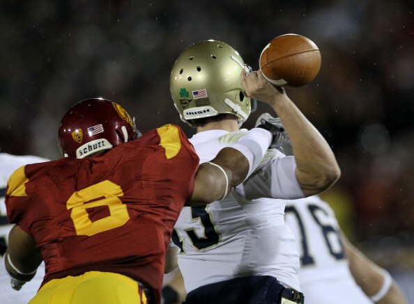 LOS ANGELES - NOVEMBER 27:  Defensive end Nick Perry #6 of the USC Trojans forces a fumble by quarterback Tommy Rees #13 of the Notre Dame Fighting Irish to set up USC's touchdown at the Los Angeles Memorial Coliseum on November 27, 2010 in Los Angeles, C
