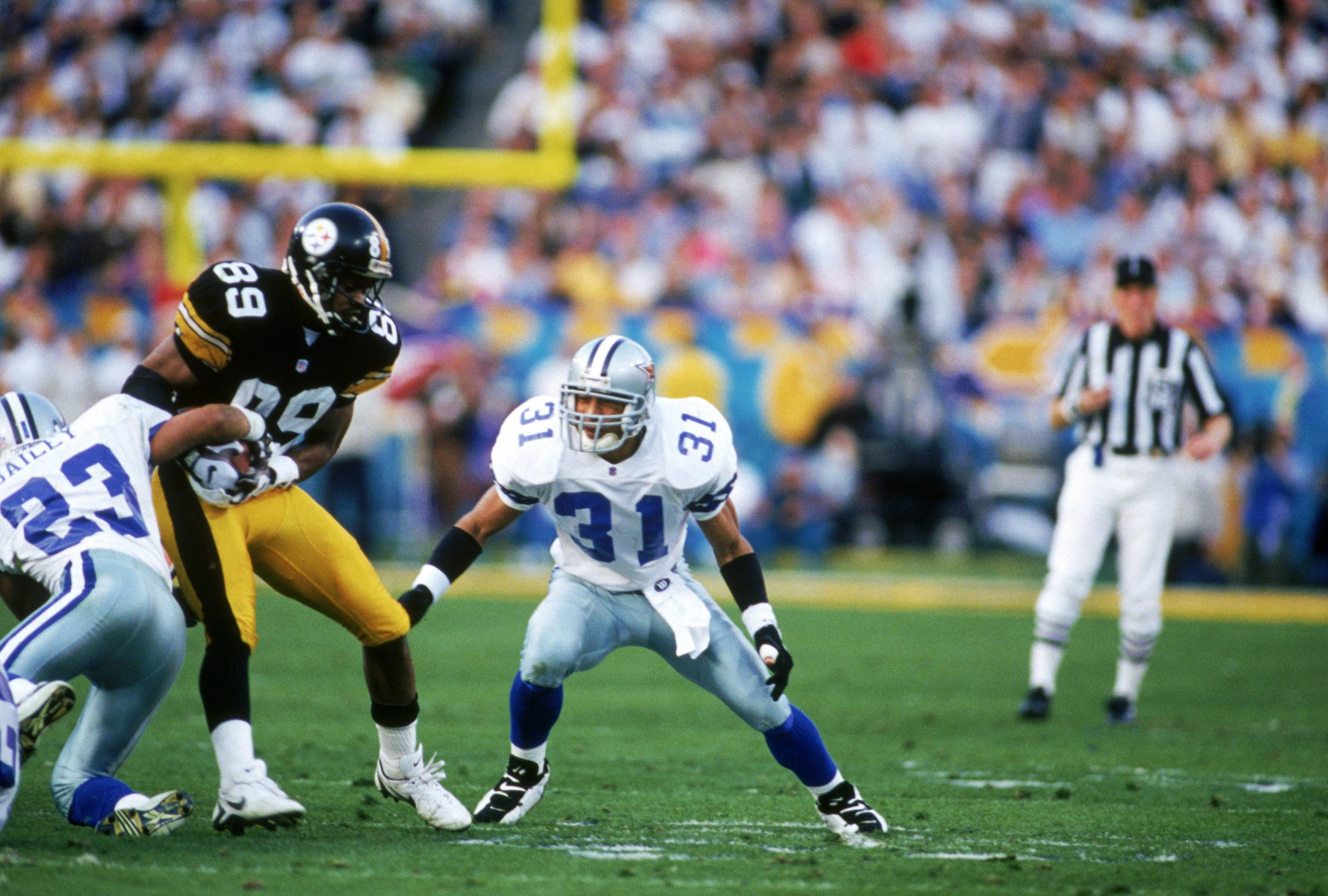 TEMPE, AZ - JANUARY 28:  Cornerback Robert Bailey #23 and safety Brock Marion #31 of the Dallas Cowboys team up to take down wide receiver Ernie Mills #89 of the Pittsburgh Steelers in Super Bowl XXX at Sun Devil Stadium on January 28, 1996 in Tempe, Ariz