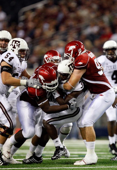 ARLINGTON, TX - OCTOBER 03:  Running back Christine Michael #33 of the Texas A&M Aggies is tackled by DeQuinta Jones #92 and Jake Bequette #91 of the Arkansas Razorbacks at Dallas Cowboys Stadium on October 3, 2009 in Arlington, Texas.  (Photo by Ronald M