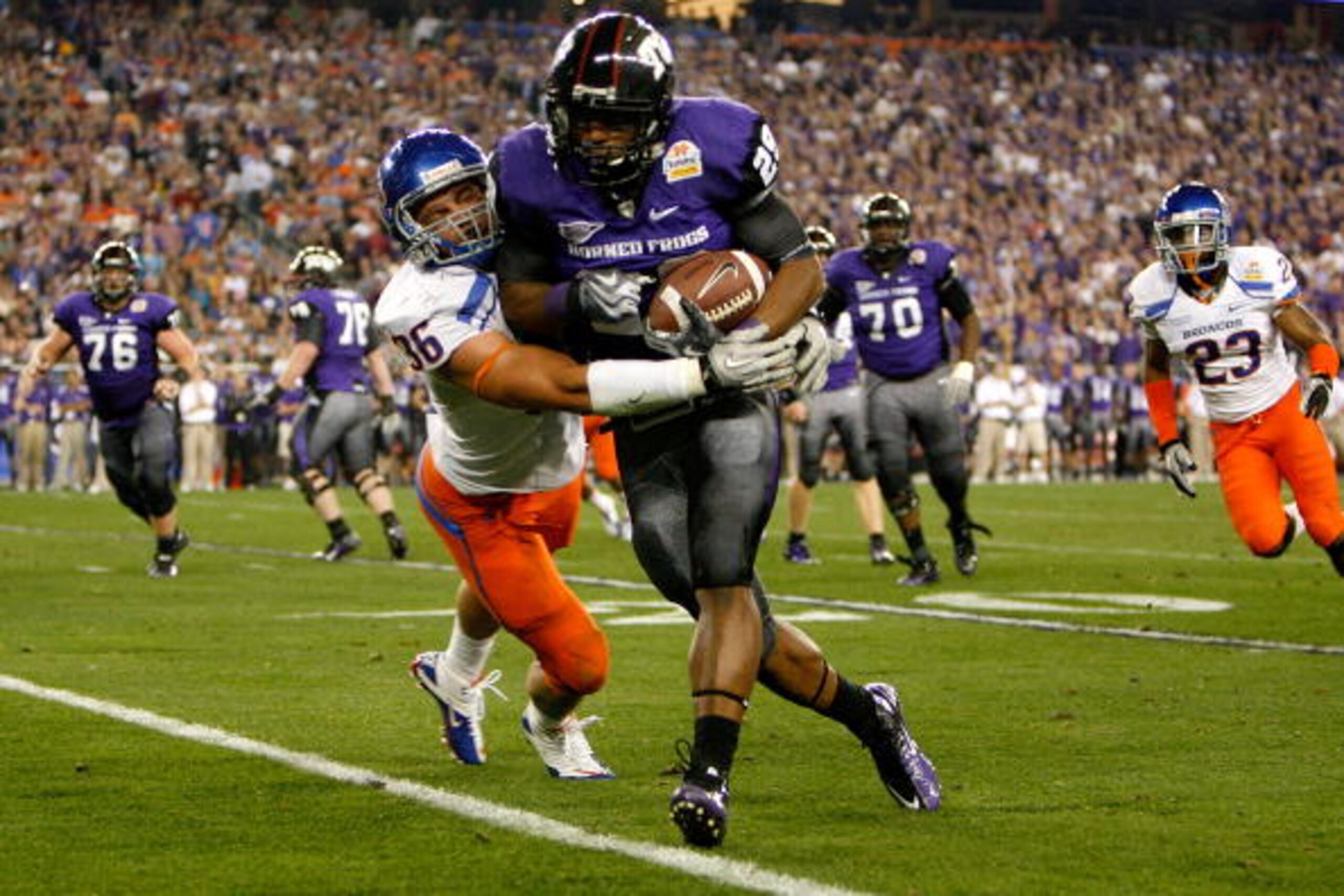GLENDALE, AZ - JANUARY 04:  Matthew Tucker #29 of the TCU Horned Frogs runs the ball as he is hit by Aaron Tevis #36 of the Boise State Broncos in the third quarter during the Tostitos Fiesta Bowl at the Universtity of Phoenix Stadium on January 4, 2010 i