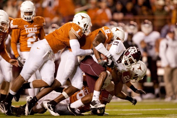 AUSTIN, TX - NOVEMBER 25:  Defensive backs Keenan Robinson #1 and Malcolm Williams #9 of the University of Texas tackle Texas A&M kick returner Kenric McNeal #81 during the first half at Darrell K. Royal-Texas Memorial Stadium on November 25, 2010 in Aust