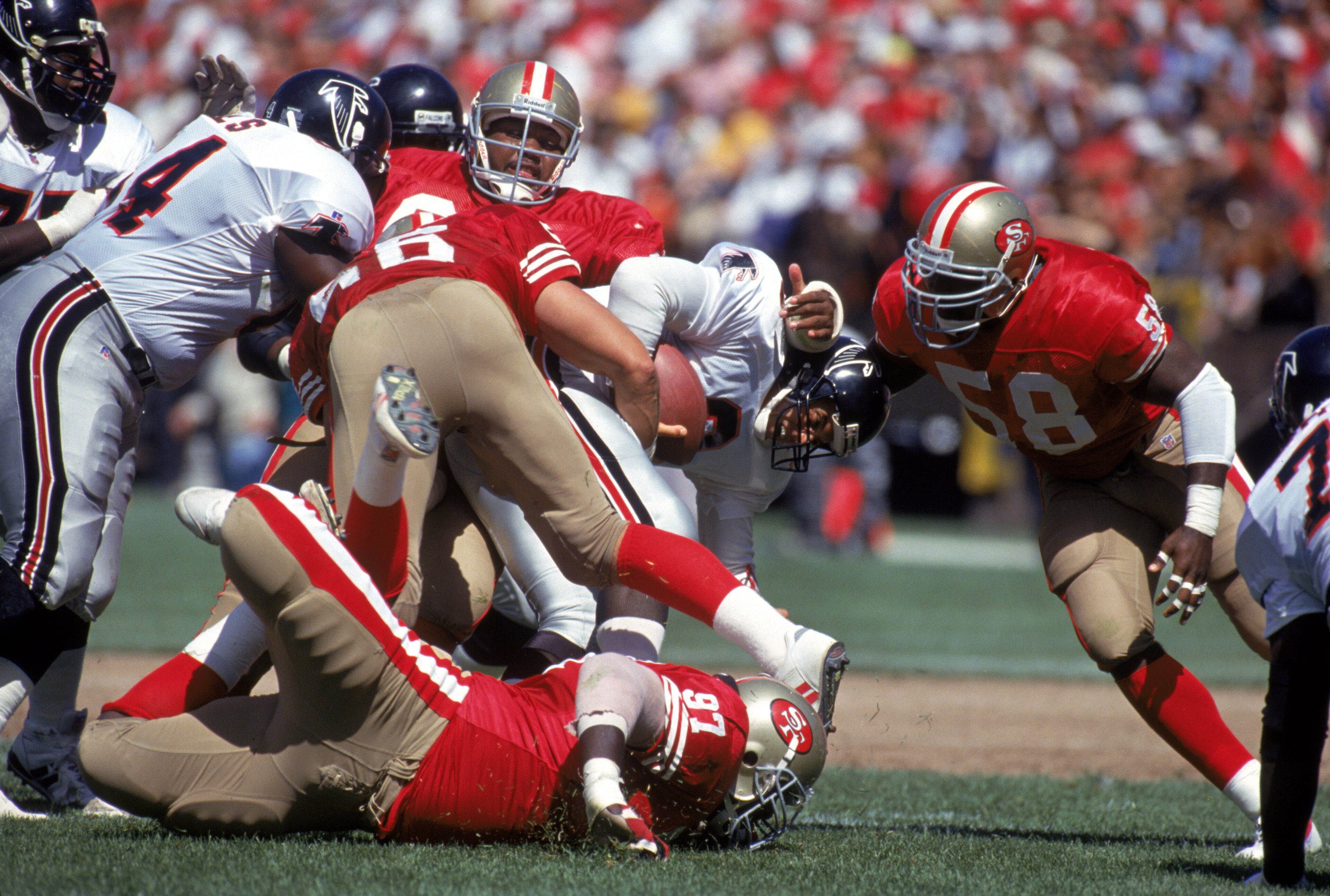 SAN FRANCISCO - SEPTEMBER 19:  Quarterback Bobby Hebert #3 of the Atlanta Falcons gets taken down by the San Francisco 49ers defense including, defensive end Todd Kelly #58, Martin Harrison #56 during a game at Candlestick Park on September 19, 1993 in Sa