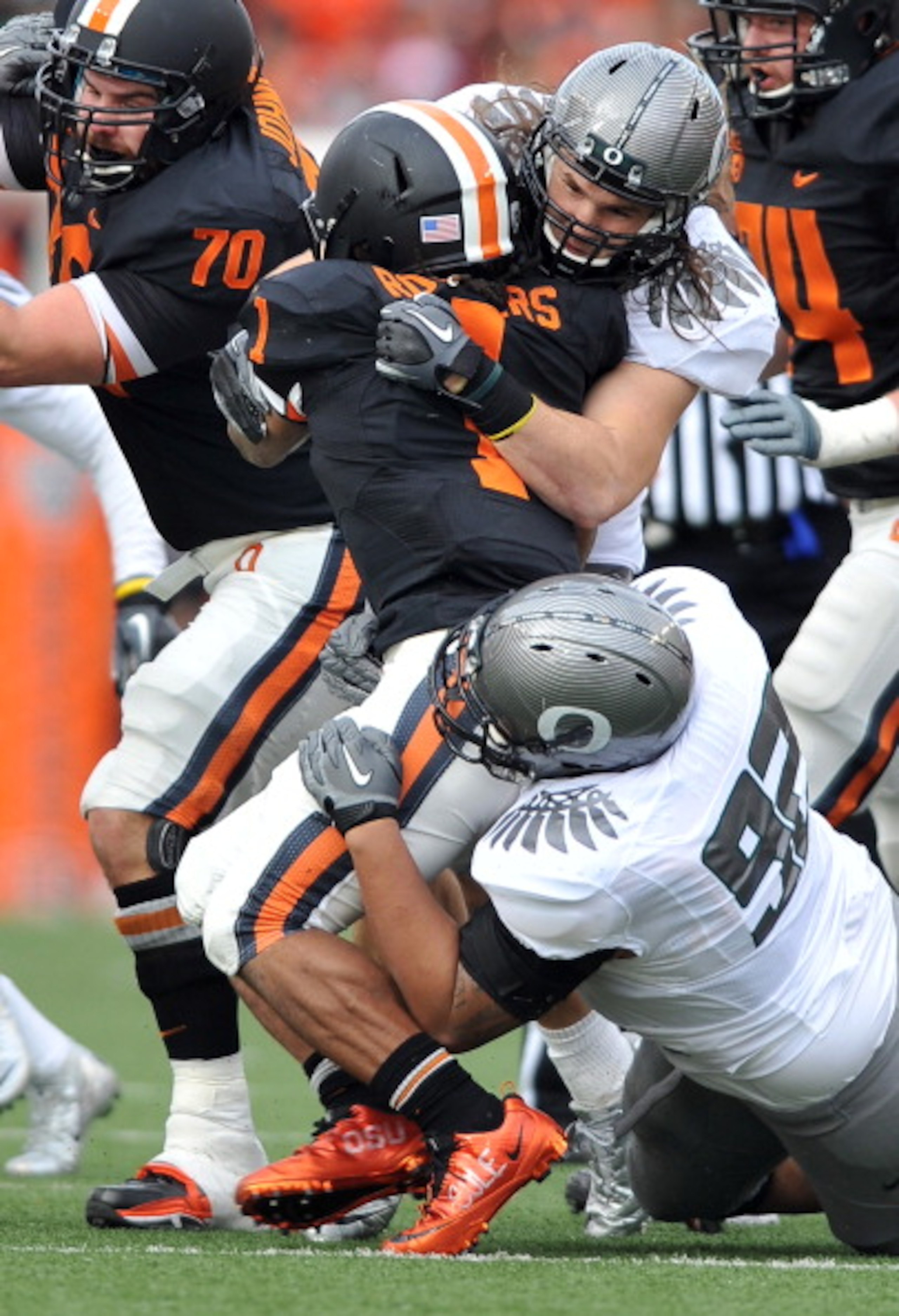 CORVALLIS, OR - DECEMBER 4: Jacquizz Rodgers #1 of the Oregon State Beavers is wrapped up by Casey Matthews #55 and Wade Keliikipi #92 of the Oregon Ducks in the first quarter of the game at Reser Stadium on December 4, 2010 in Corvallis, Oregon. The Duck CORVALLIS, OR - DECEMBER 4: Jacquizz Rodgers #1 of the Oregon State Beavers is wrapped up by Casey Matthews #55 and Wade Keliikipi #92 of the Oregon Ducks in the first quarter of the game at Reser Stadium on December 4, 2010 in Corvallis, Oregon. The Duck