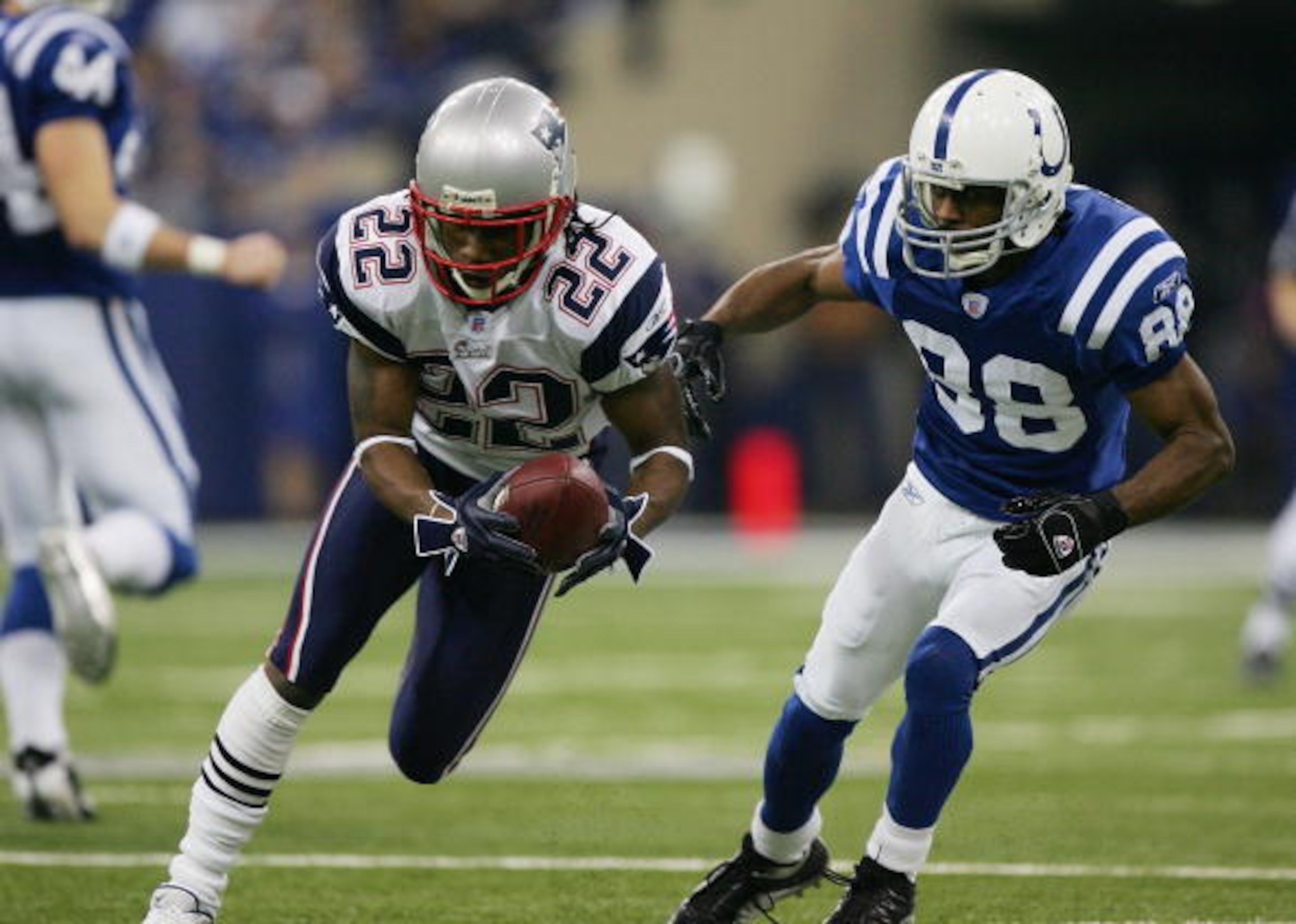 INDIANAPOLIS - JANUARY 21:  Asante Samuel #22 of the New England Patriots runs back an interception for a touchdown in front of Marvin Harrison #88 of the Indianapolis Colts during the second quarter against the Indianapolis Colts during the AFC Champions