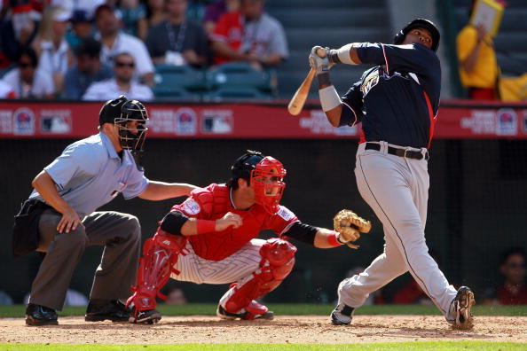 ANAHEIM, CA - JULY 11:  U.S. Futures All-Star Austin Romine #4 of the New York Yankees prepares for the catch as World Futures All-Star Carlos Peguero #23 of the Seattle Mariners is swings for the ball during the 2010 XM All-Star Futures Game at Angel Sta