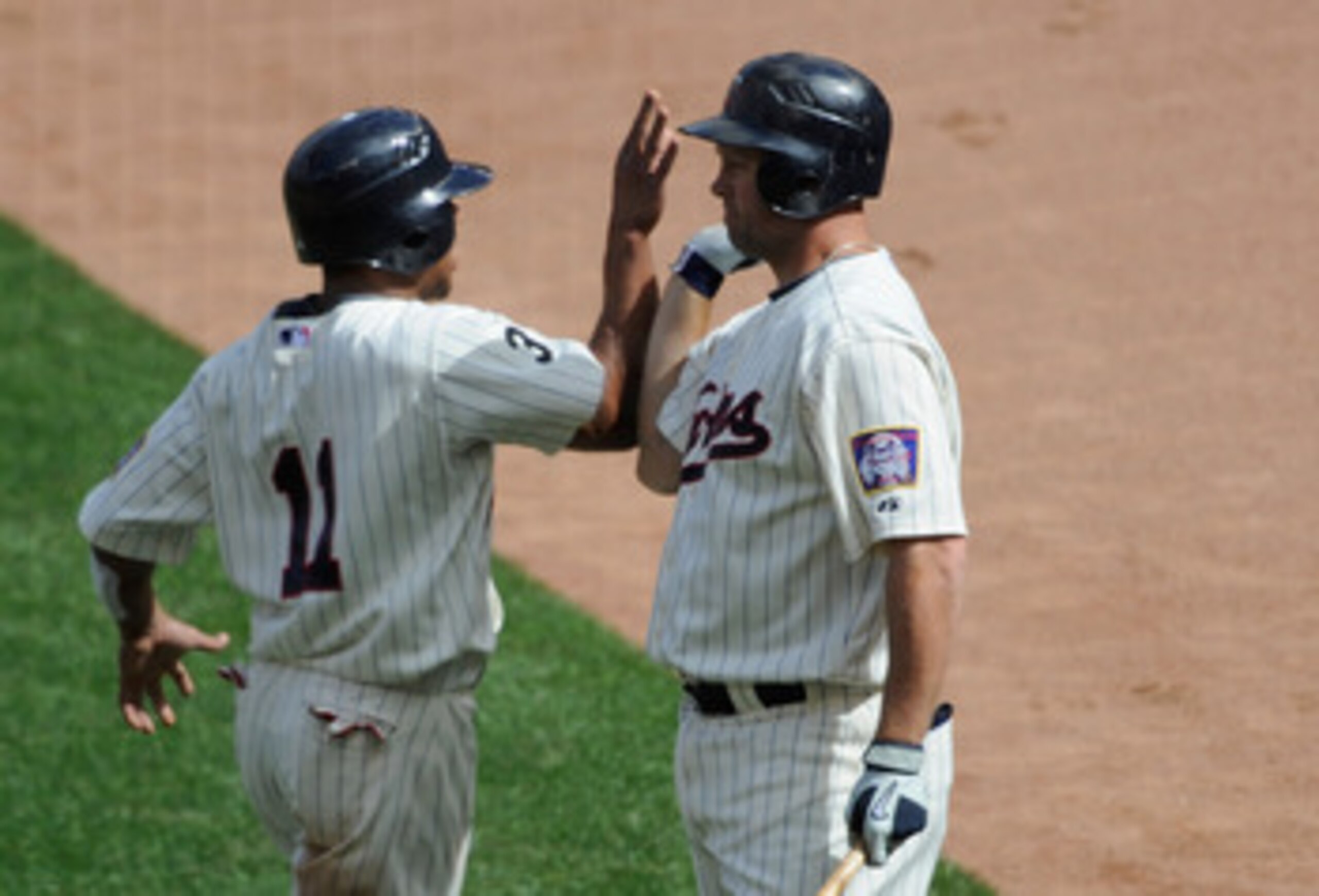 MINNEAPOLIS, MN - JUNE 11: Ben Revere #11 and Michael Cuddyer #5 of the Minnesota Twins celebrate Revere scoring against the Texas Rangers during the fourth inning of their game on June 11, 2011 at Target Field in Minneapolis, Minnesota. The Twins defeate