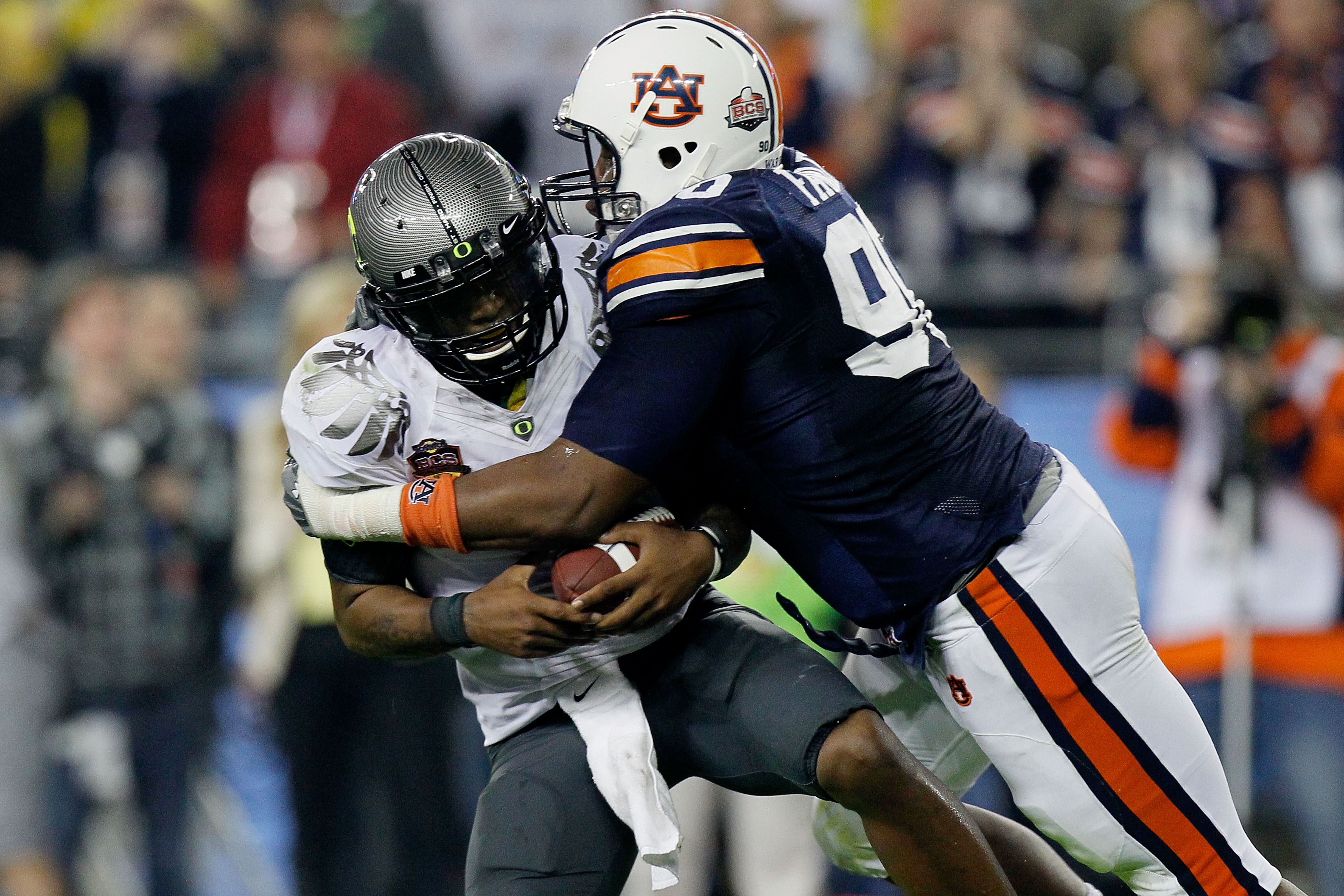 GLENDALE, AZ - JANUARY 10:  Quarterback Darron Thomas #1 of the Oregon Ducks is sacked by Nick Fairley #90 of the Auburn Tigers in the first half in the Tostitos BCS National Championship Game at University of Phoenix Stadium on January 10, 2011 in Glenda