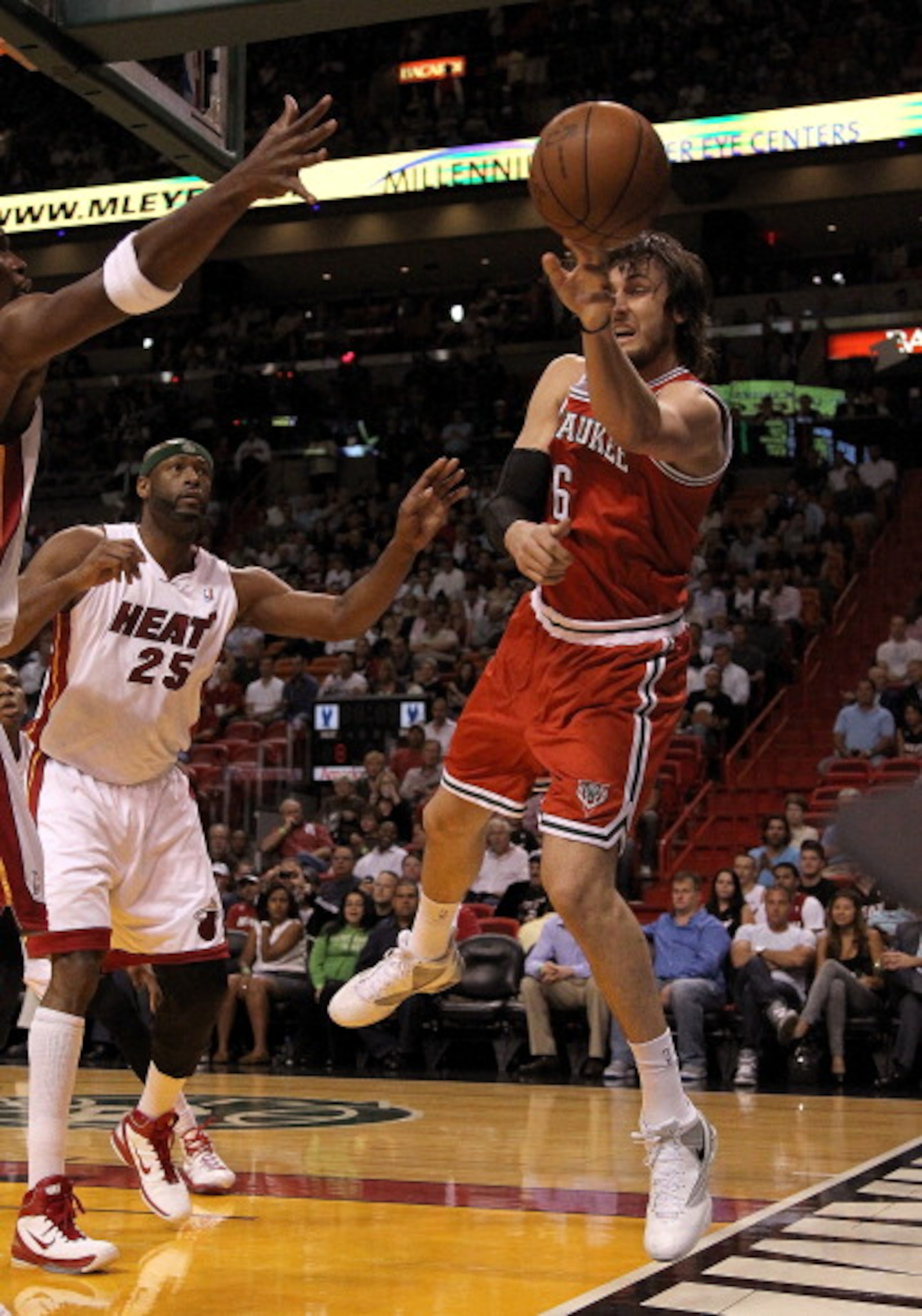 MIAMI, FL - APRIL 06:  Andrew Bogut #6 of the Milwaukee Bucks passes away from  Eric Dampier #25 of the Miami Heat during a game at American Airlines Arena on April 6, 2011 in Miami, Florida. NOTE TO USER: User expressly acknowledges and agrees that, by d