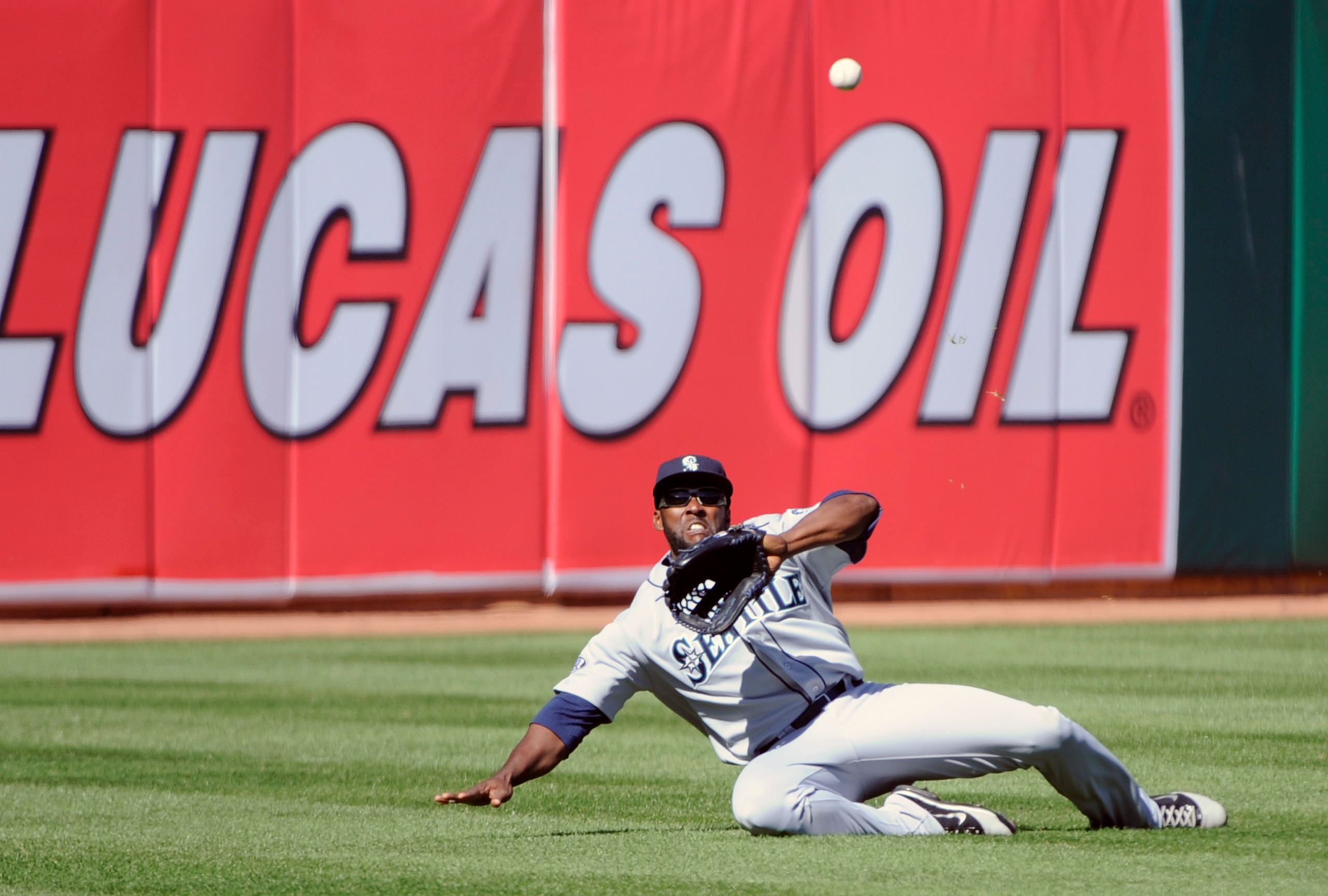 OAKLAND, CA - APRIL 3: Milton Bradley #15 of the Seattle Mariners makes a sliding catch in left-field against the Oakland Athletics during a MLB baseball game at the Oakland-Alameda County Coliseum April 3, 2011 in Oakland, California.  (Photo by Thearon 