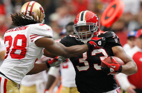 ATLANTA - OCTOBER 03:  Michael Turner #33 of the Atlanta Falcons stiff arms Dashon Goldson #38 of the San Francisco 49ers at Georgia Dome on October 3, 2010 in Atlanta, Georgia.  (Photo by Kevin C. Cox/Getty Images)