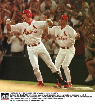 SLP98090817- 08 SEPTEMBER 1998- ST. LOUIS, MISSOURI, USA: St. Louis Cardinals'' Mark McGwire hops around first base, but then has to go back and touch it with the help of first base coach Dave McKay, after McGwire blasted his 62nd home run of the season,