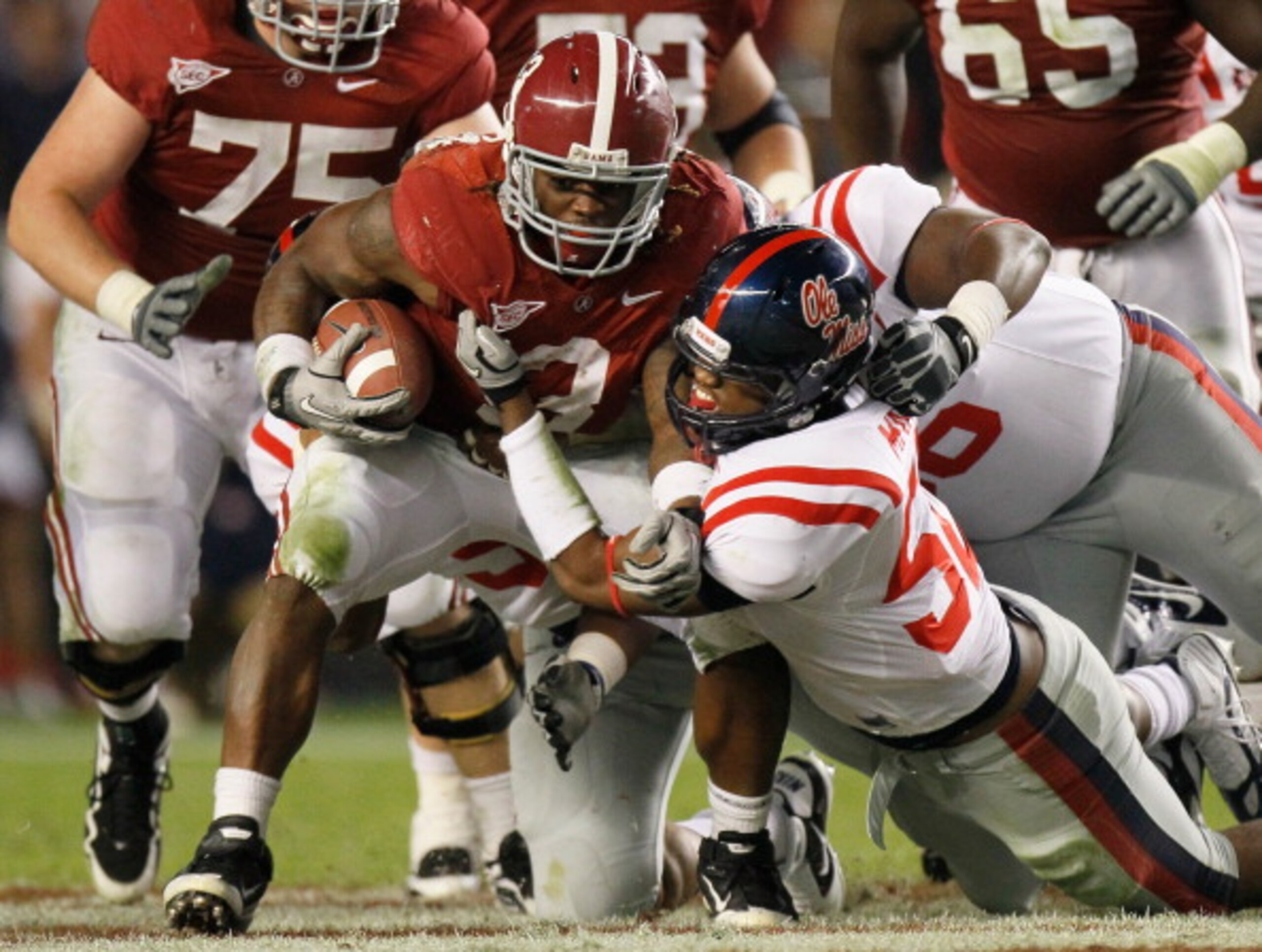 TUSCALOOSA, AL - OCTOBER 16:  Trent Richardson #3 of the Alabama Crimson Tide pushes for more yardage against Mike Marry #52 and Lawon Scott #96 of the Ole Miss Rebels at Bryant-Denny Stadium on October 16, 2010 in Tuscaloosa, Alabama.  (Photo by Kevin C.