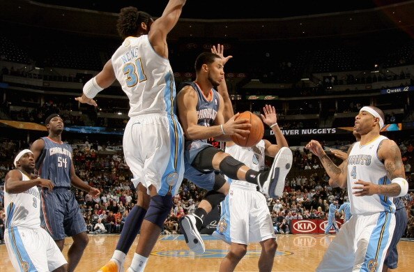 DENVER, CO - MARCH 02:  D.J. Augustin #14 of the Charlotte Bobcats looks to pass the ball against Nene #31, Arron Afflalo #6 and Kenyon Martin #4 of the Denver Nuggets at the Pepsi Center on March 2, 2011 in Denver, Colorado. The Nuggets defeated the Bobc