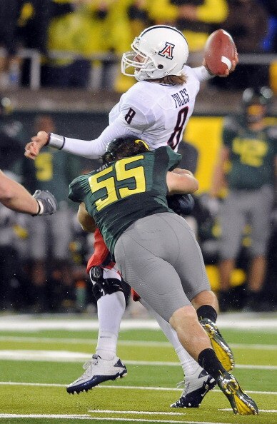 EUGENE, OR - NOVEMBER 26: Quarterback Nick Foles #8 of the Arizona Wildcats is hit by linebacker Casey Matthews #55 of the Oregon Ducks as he throws a pass in the third quarter of the game at Autzen Stadium on November 26, 2010 in Eugene, Oregon.The Ducks