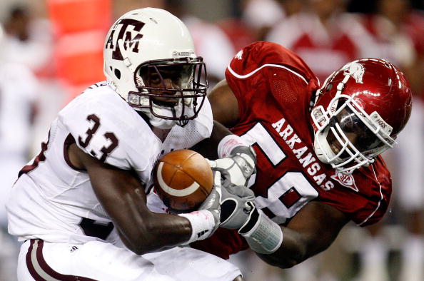 ARLINGTON, TX - OCTOBER 03:  Running back Christine Michael #33 of the Texas A&M Aggies runs the ball against Damario Ambrose #58 of the Arkansas Razorbacks at Cowboys Stadium on October 3, 2009 in Arlington, Texas.  (Photo by Ronald Martinez/Getty Images