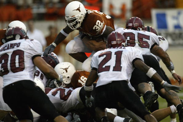 AUSTIN, TX - AUGUST 31:  Running back Cedric Benson #32 of the University of Texas at Austin Longhorns leaps over the New Mexico State University Aggies during the game Texas Memorial Stadium on August 31, 2003 in Austin, Texas. Texas defeated New Mexico 